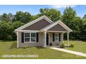 Well-maintained single-story home featuring tidy landscaping and attractive neutral siding at 209 S Gregory St # 3, Lancaster, SC 29720