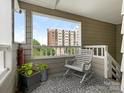 Cozy balcony with rocking chair and lush outdoor views of mature trees and nearby highrise at 212 W 10Th St # 3, Charlotte, NC 28202