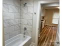 Bathroom boasting marble tiled walls, sleek fixtures, and a view into the kitchen at 216 N Vance St, Gastonia, NC 28052