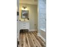 Bright bathroom with marble tiled wall, modern vanity, and new wood flooring at 216 N Vance St, Gastonia, NC 28052