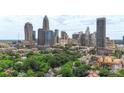 Aerial view of city skyline with surrounding neighborhood and lush green trees and blue skies at 224 N Poplar St # 24, Charlotte, NC 28202