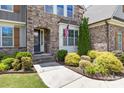 Close up of the entryway featuring a stone facade, blue front door, and lush landscaping at 2414 Madeira Cir, Waxhaw, NC 28173