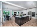 Open-concept kitchen with stainless steel appliances and a large island overlooking the living room at 4005 Easton Ridge Ln, Charlotte, NC 28226
