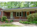 Detailed view of the covered front porch, featuring brick accents and iron railings at 403 Cherrywood Ln, Albemarle, NC 28001
