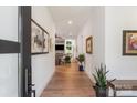 Bright hallway with hardwood floors, white walls, and artwork leading to the living area at 4108 Commonwealth Ave, Charlotte, NC 28205