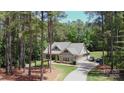Secluded home nestled among tall trees, featuring a long driveway and an attached garage at 4660 Gold Finch Dr, Denver, NC 28037