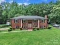 Beautiful exterior elevation of a red brick home with a lush green front yard at 5633 Mallard S Dr, Charlotte, NC 28227