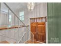 Foyer featuring wood floors, stairway, and a hanging chandelier light fixture at 5633 Mallard S Dr, Charlotte, NC 28227