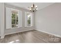 Well-lit dining room with hardwood floors, a modern chandelier, and natural light at 6614 Truman St, Indian Trail, NC 28079