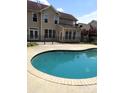 Backyard view showcasing the sparkling in-ground swimming pool surrounded by a concrete patio and black metal fence at 6614 Truman St, Indian Trail, NC 28079