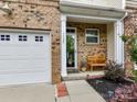 Front entrance with a covered porch, bench, and well-kept landscaping, next to one-car garage at 7325 Overmountain Dr, Rock Hill, SC 29732
