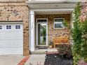 Inviting front entry featuring a covered porch area with a bench and brick accents near garage at 7325 Overmountain Dr, Rock Hill, SC 29732
