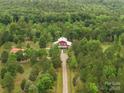 Aerial view of a stunning property surrounded by lush forest, showcasing its secluded location and charming red home at 925 Hamilton Rd, Chester, SC 29706