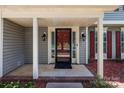 Inviting front porch featuring a red front door with glass accents and classic outdoor sconces at 10327 Shelter Rock Ct, Charlotte, NC 28214