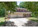 Attractive two-story home featuring a two-car garage, red shutters, and a well-maintained lawn at 10327 Shelter Rock Ct, Charlotte, NC 28214