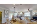 Open concept kitchen with island flows seamlessly into a dining area and living room with natural light at 106 Noah Ln, Troutman, NC 28166