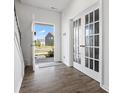 Bright entryway features wood flooring and adjacent glass paneled doors to flex space and open view to exterior at 1433 Harleston St, Indian Trail, NC 28079
