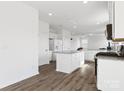 Spacious kitchen with white cabinetry, granite countertops, stainless appliances, and an island with breakfast bar seating at 1433 Harleston St, Indian Trail, NC 28079
