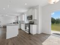 Open kitchen with stainless steel appliances, granite counters, and access to backyard at 1433 Harleston St, Indian Trail, NC 28079