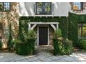 Close up of the home's entry way with ivy, stone steps and an arched facade at 1550 Queens W Rd, Charlotte, NC 28207