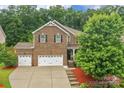 Beautiful brick house with a three-car garage and lush green surroundings at 1919 Madeira Cir, Waxhaw, NC 28173
