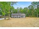 Inviting one-story home with gray siding surrounded by mature trees and a spacious front yard at 195 Linda St, Salisbury, NC 28146