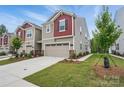 Side view of a two-story home with a driveway, landscaping, and well-manicured lawn at 2021 Vinyasa Ln # Sts-41, Charlotte, NC 28215