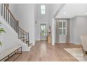 Bright foyer features hardwood floors, staircase with iron railing, and an abundance of natural light at 2026 Thatcher Way, Fort Mill, SC 29715