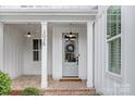 Inviting covered front porch with brick flooring, pendant lights, and columns that create a warm welcome at 2026 Thatcher Way, Fort Mill, SC 29715