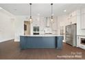Modern kitchen featuring a large island with seating, stainless steel appliances, and ample cabinet space at 20392 Queens St, Cornelius, NC 28031