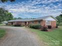 Attractive brick home featuring a landscaped yard, gravel driveway, and a covered carport at 269 Johnson Dairy Rd, Mooresville, NC 28115