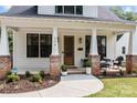 Inviting front porch with brick columns, decorative plants, and stylish seating arrangement at 304 Keswick Ave, Charlotte, NC 28206