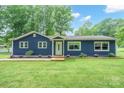 Charming home with a blue exterior, a well-manicured lawn, and delightful landscaping at 327 Holly Dr, Mount Holly, NC 28120