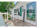 Inviting front porch with a welcome sign, green shutters, and a glass front door at 338 Hickory Grove Rd, Harmony, NC 28634