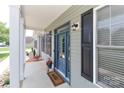 Close-up of a blue front door with black shutters, a welcoming mat, and a decorative flower pot at 3709 Creek Ridge Dr, Denver, NC 28037