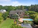 Backyard aerial view featuring an in-ground pool, well-maintained landscaping, and a screened-in porch at 389 Ponderosa Cir, Mooresville, NC 28117