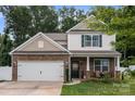 Attractive two-story home with stone accents, a two-car garage, and a welcoming front porch at 413 Wheat Field Dr, Mount Holly, NC 28120