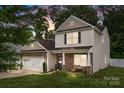 Charming two-story home featuring stone accents, a cozy porch, and well-manicured landscaping at 413 Wheat Field Dr, Mount Holly, NC 28120