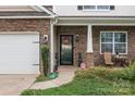 Inviting covered front porch with decorative stone pillars and a cozy seating area at 413 Wheat Field Dr, Mount Holly, NC 28120