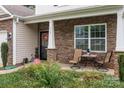 Charming covered front porch with comfortable seating and decorative stone accents at 413 Wheat Field Dr, Mount Holly, NC 28120