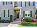 Inviting front entrance with decorative wreath, stone accents, and well-maintained landscaping at 4151 Green Park Ct, Harrisburg, NC 28075