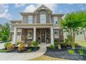 Beautiful two-story home showcasing a stone facade, landscaped garden, and a welcoming front porch at 515 Lizzie Ln, Fort Mill, SC 29708