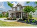 Charming two-story home with stone accents, landscaped front yard, and cozy front porch seating area at 515 Lizzie Ln, Fort Mill, SC 29708
