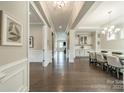 Spacious hallway leading to dining area with hardwood floors, white trim, and elegant chandelier at 515 Lizzie Ln, Fort Mill, SC 29708