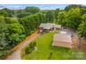 Picturesque aerial view of property showcasing brick home, detached garage and private driveway at 648 Odell School Rd, Concord, NC 28027