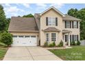 Two-story home with a well-manicured lawn and attached two-car garage in front of house at 6608 Pattonsburg Dr, Charlotte, NC 28213