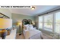 Cozy bedroom with a large window offering ample natural light, complemented by stylish decor at 674 Georgie St, Troutman, NC 28166