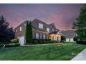 Brick home featuring a two-car garage, manicured landscaping, and well-maintained lawn at 8301 Caesars Head Dr, Waxhaw, NC 28173