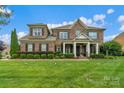 Charming two-story brick home featuring a welcoming front porch and manicured landscaping at 8301 Caesars Head Dr, Waxhaw, NC 28173