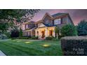 Charming two-story brick home featuring a welcoming front porch and manicured landscaping at 8301 Caesars Head Dr, Waxhaw, NC 28173